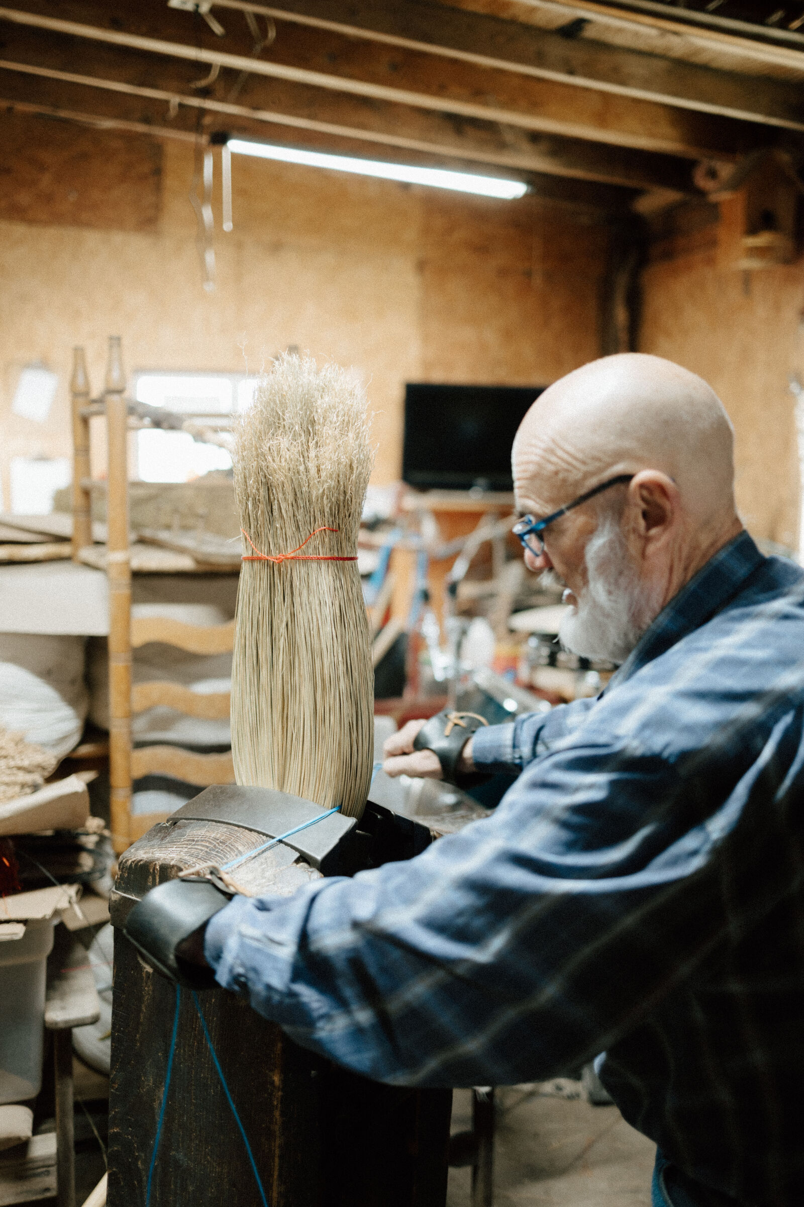 A broom maker at work at Hockaday Handmade Brooms
